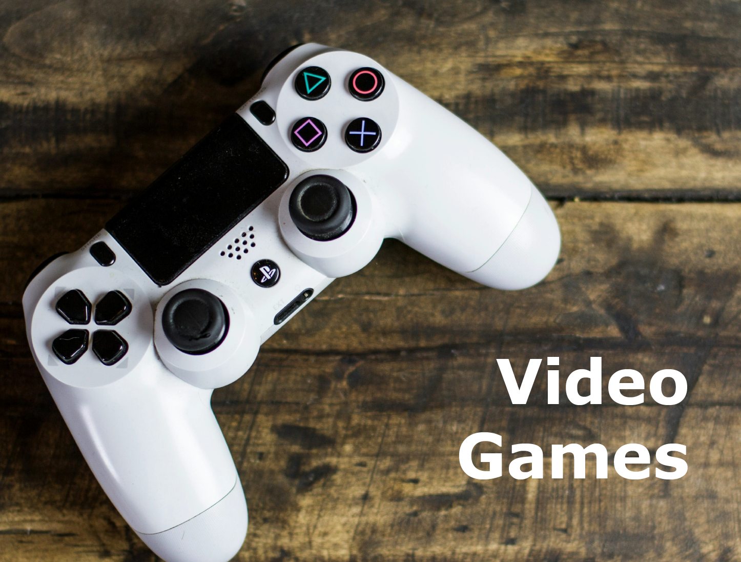 Image button for video games, close up of white controller on wood background